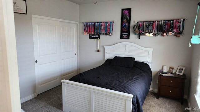 carpeted bedroom with baseboards and a closet