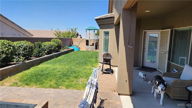 view of yard featuring a patio area, a playground, and a fenced backyard