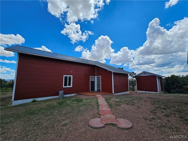 back of house featuring metal roof