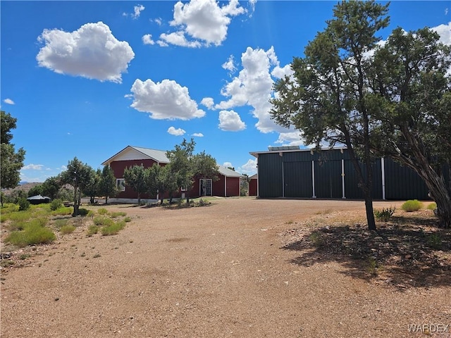 view of yard featuring driveway and an outbuilding