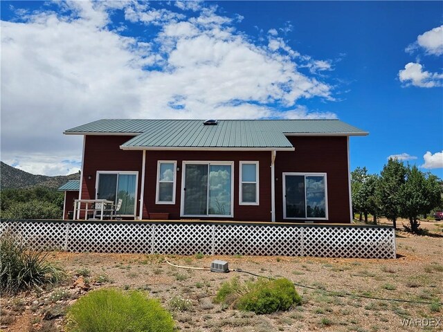 rear view of house with entry steps, metal roof, and a mountain view