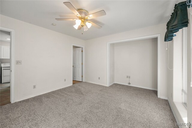 unfurnished bedroom with washer / dryer, carpet, baseboards, and a ceiling fan