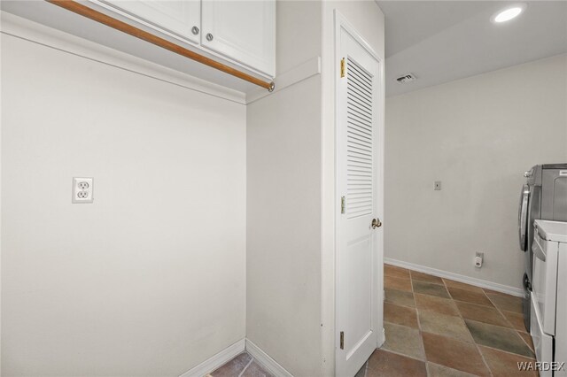 laundry area featuring baseboards, visible vents, cabinet space, and washer and dryer