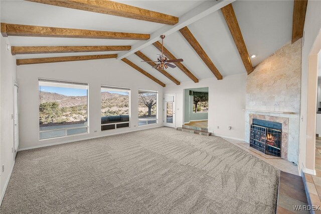 unfurnished living room with baseboards, ceiling fan, beamed ceiling, carpet floors, and a high end fireplace