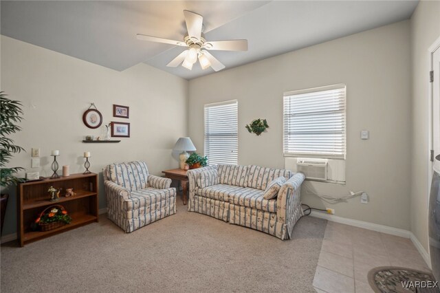 living area with light tile patterned floors, cooling unit, a ceiling fan, and baseboards