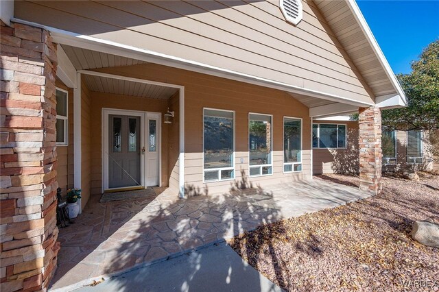 view of exterior entry with a patio area