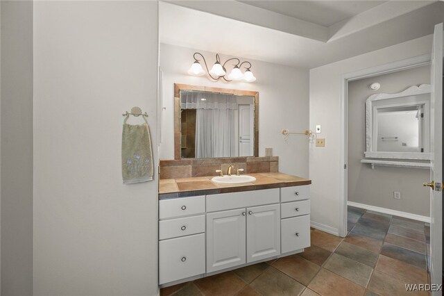 bathroom with decorative backsplash, vanity, and baseboards