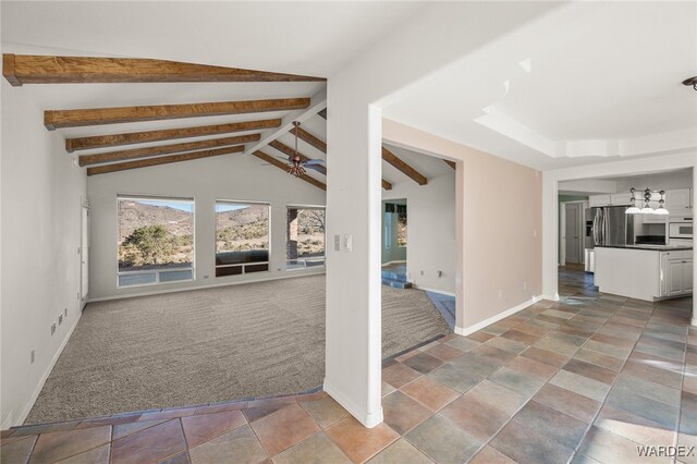 unfurnished living room with light carpet, lofted ceiling with beams, a ceiling fan, and baseboards