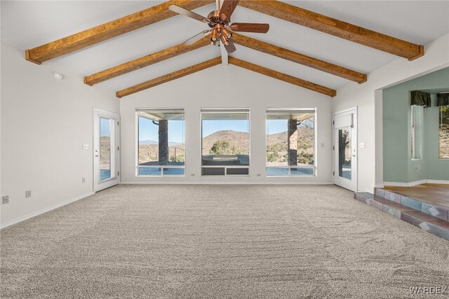 unfurnished living room featuring carpet, lofted ceiling with beams, plenty of natural light, and a mountain view