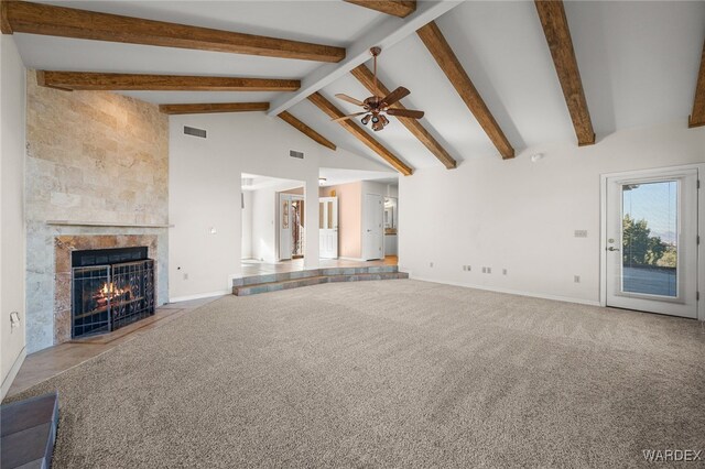 unfurnished living room featuring high vaulted ceiling, light colored carpet, a fireplace, visible vents, and beamed ceiling