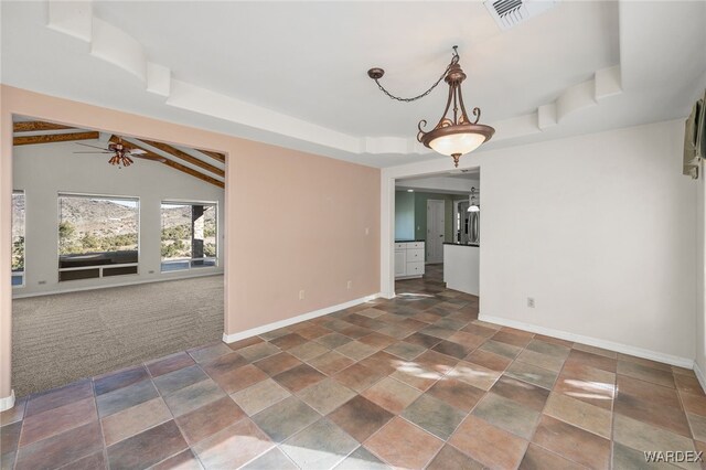 unfurnished dining area with baseboards, visible vents, a raised ceiling, lofted ceiling with beams, and dark colored carpet