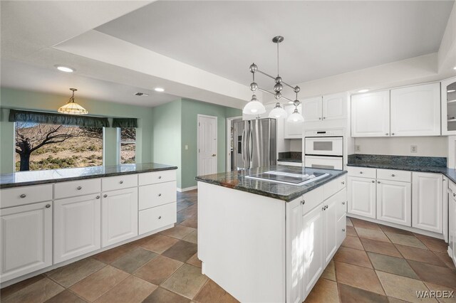 kitchen with a kitchen island, glass insert cabinets, decorative light fixtures, white cabinetry, and stainless steel refrigerator with ice dispenser