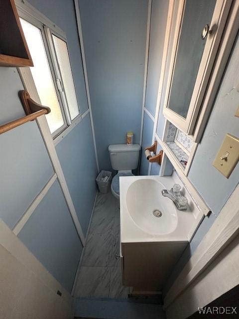 half bathroom with vanity and toilet