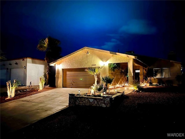 view of front of house with a garage, driveway, and stucco siding