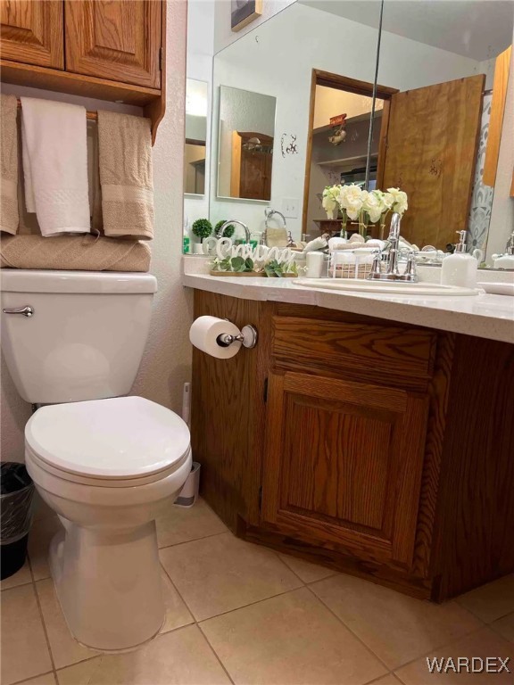 bathroom featuring toilet, vanity, and tile patterned floors