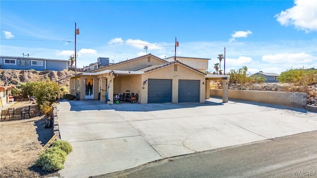 single story home with a garage, driveway, and stucco siding