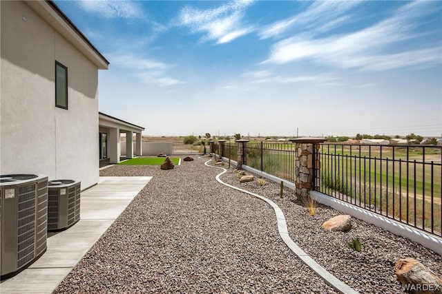 view of yard with central AC, a patio, and a fenced backyard