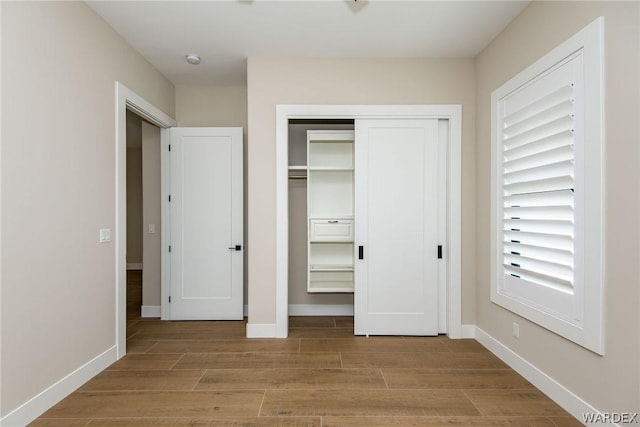 unfurnished bedroom with baseboards, a closet, and light wood-style floors