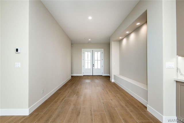 interior space featuring light wood finished floors, recessed lighting, baseboards, and french doors