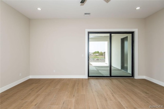 unfurnished room with light wood-type flooring, visible vents, baseboards, and recessed lighting