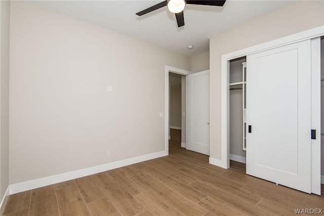 unfurnished bedroom with a ceiling fan, light wood-style flooring, baseboards, and a closet