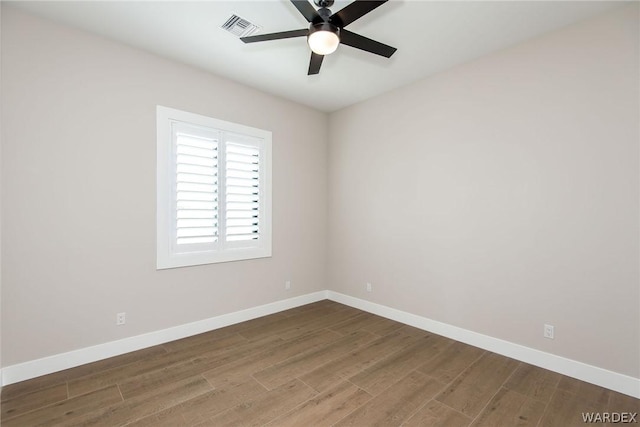 empty room with a ceiling fan, baseboards, visible vents, and wood finished floors