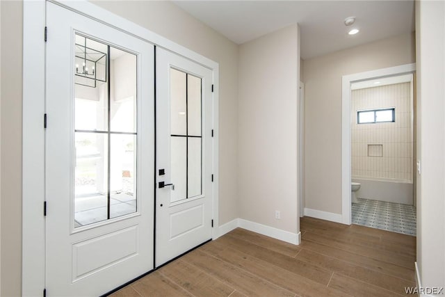 foyer entrance featuring a chandelier, recessed lighting, baseboards, and light wood finished floors