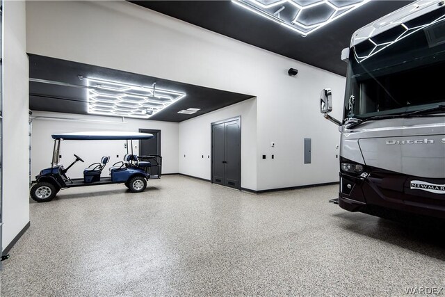 garage featuring electric panel and baseboards