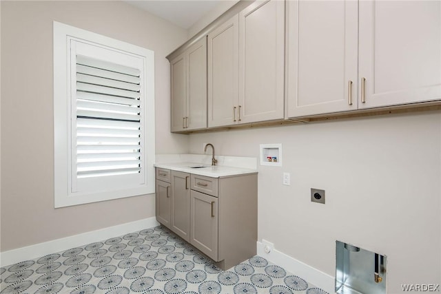 washroom with hookup for a washing machine, a sink, baseboards, cabinet space, and electric dryer hookup