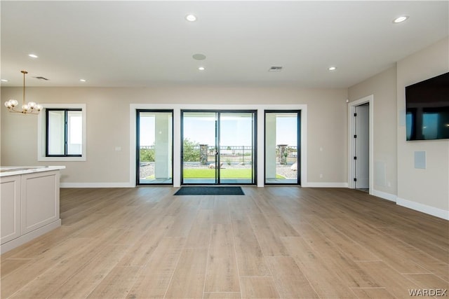 unfurnished living room featuring recessed lighting, visible vents, light wood-style flooring, and baseboards