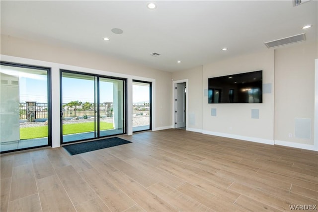 spare room with baseboards, visible vents, light wood-style flooring, and recessed lighting