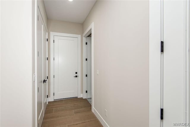 hallway with wood finish floors and baseboards