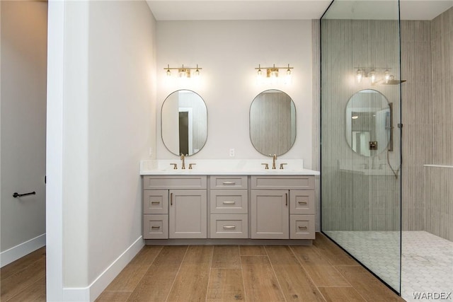 bathroom featuring double vanity, a sink, and wood finished floors