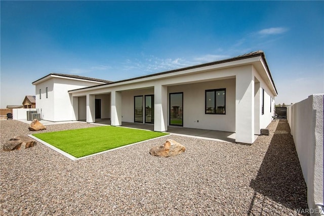 rear view of house with a patio area, a fenced backyard, and stucco siding