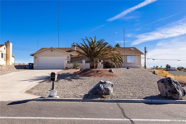 view of front of property featuring driveway, an attached garage, and stucco siding