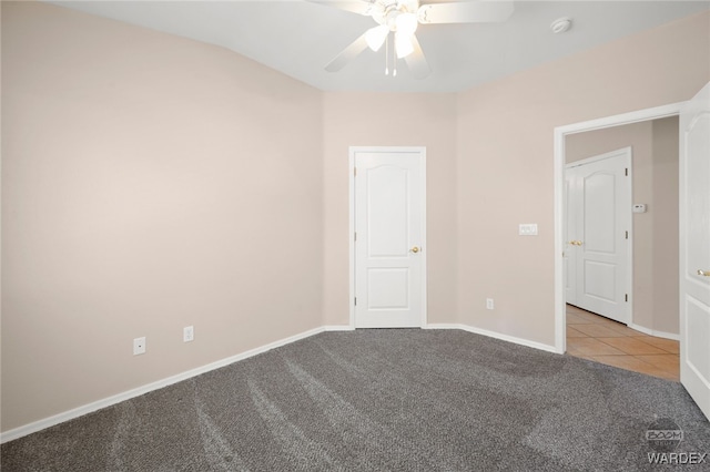 unfurnished room featuring ceiling fan, carpet floors, tile patterned flooring, and baseboards