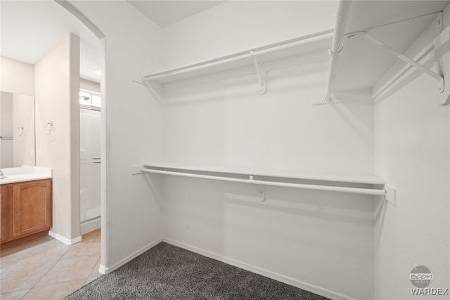 spacious closet with arched walkways and light tile patterned flooring