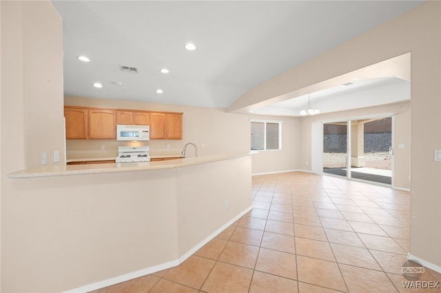 kitchen featuring light tile patterned floors, recessed lighting, a notable chandelier, white appliances, and light countertops