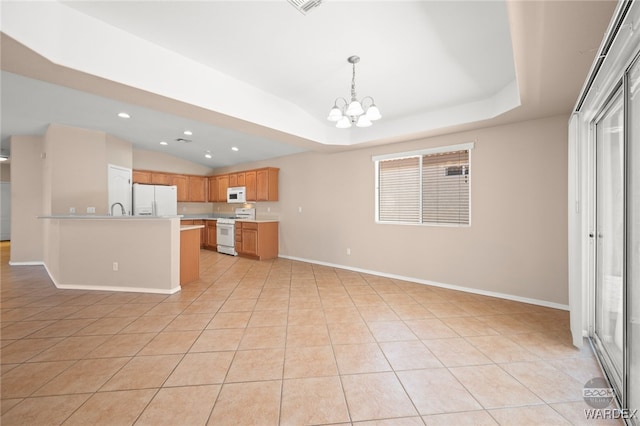 kitchen with light tile patterned floors, a notable chandelier, white appliances, light countertops, and a raised ceiling