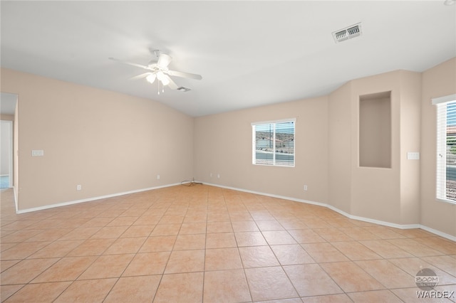 unfurnished room with ceiling fan, light tile patterned flooring, visible vents, and baseboards