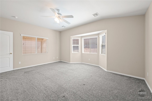 carpeted empty room featuring baseboards, visible vents, and a ceiling fan