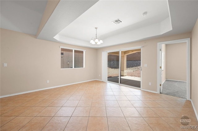 unfurnished room featuring visible vents, baseboards, a tray ceiling, a chandelier, and light tile patterned flooring