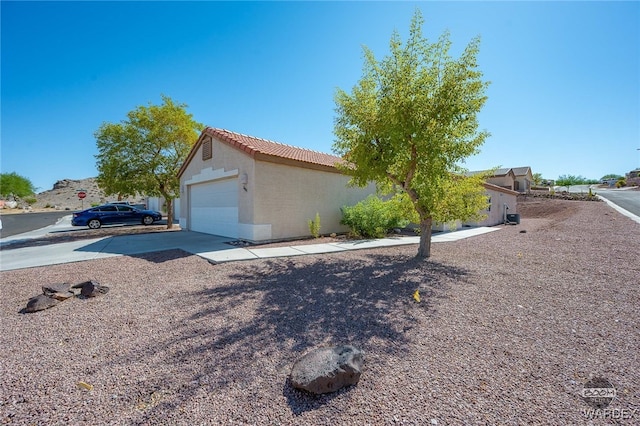 view of front of home with a garage, a tile roof, and stucco siding