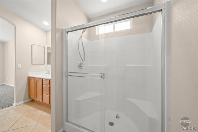 full bathroom with baseboards, tile patterned flooring, vanity, and a shower stall