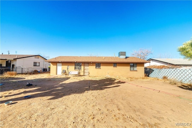 rear view of property featuring fence and central air condition unit