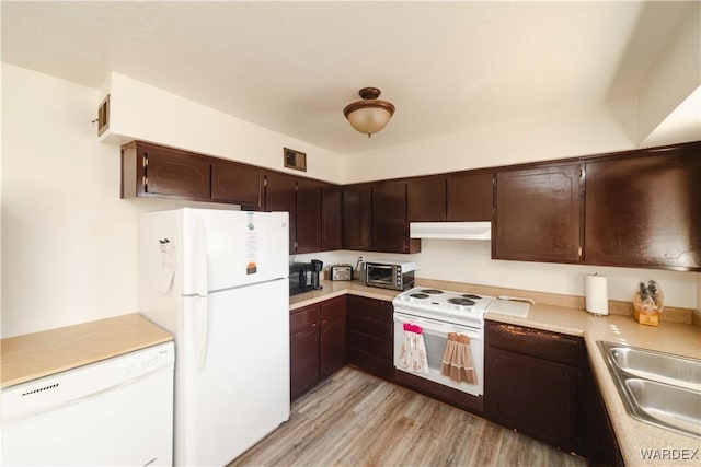 kitchen with light countertops, light wood-style flooring, a sink, white appliances, and under cabinet range hood