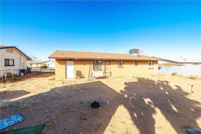 back of property with fence and cooling unit