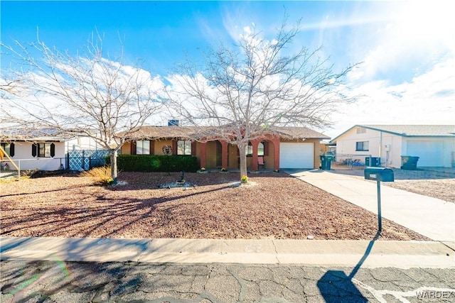 ranch-style house featuring concrete driveway, an attached garage, fence, and stucco siding