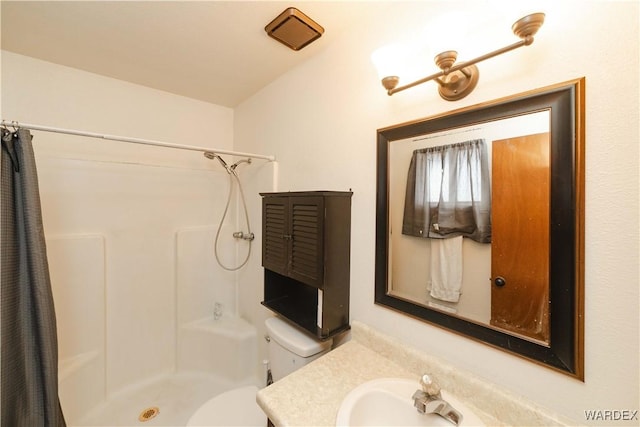 full bath with vanity, a shower stall, and toilet