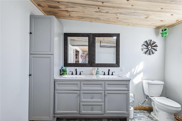 bathroom featuring double vanity, wooden ceiling, a sink, and toilet